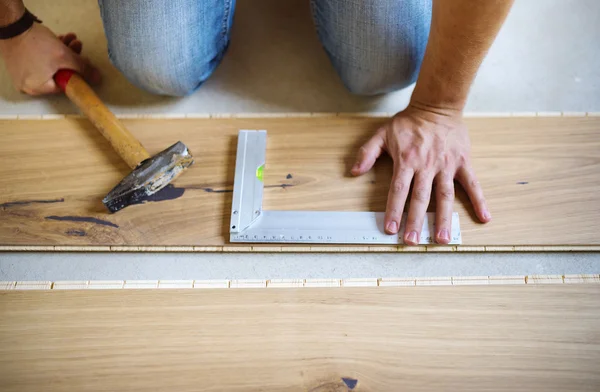Hands measuring wood flooring — Stock Photo, Image