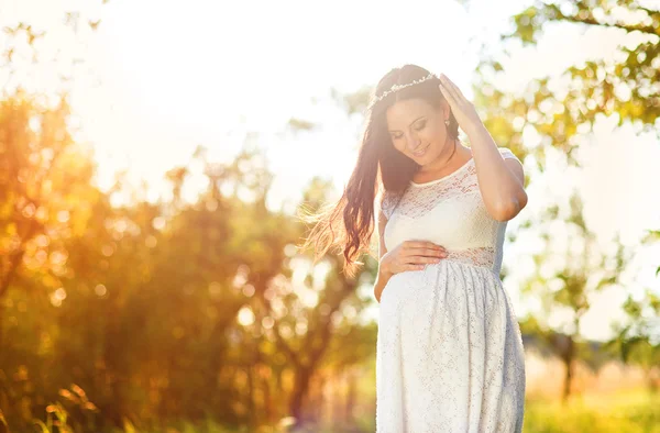 Беременная женщина в белом платье — стоковое фото
