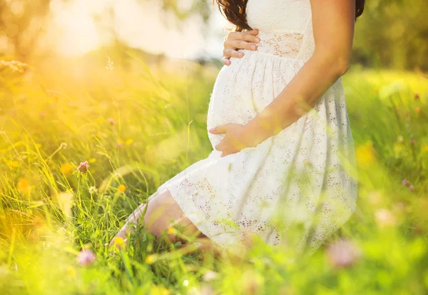 Gravid kvinna i vit klänning — Stockfoto