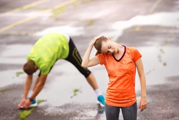 Paar streckt sich nach dem Lauf — Stockfoto