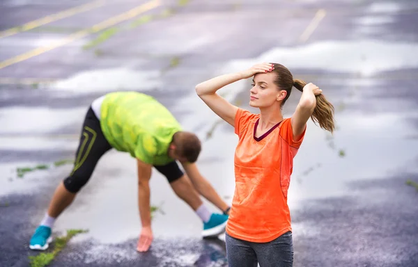 Pareja estirándose después de la carrera —  Fotos de Stock