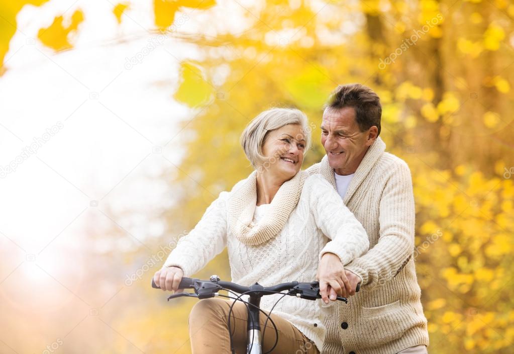 Senior couple enjoying walk with bicycle