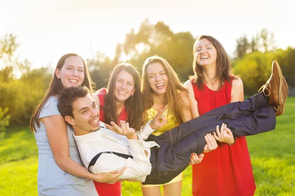 Bruidsmeisjes houden bruidegom — Stockfoto