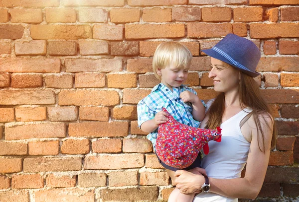 Anya és fia, átölelve a tégla fal — Stock Fotó