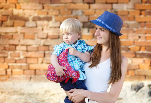 Madre e hijo abrazándose por la pared de ladrillo —  Fotos de Stock