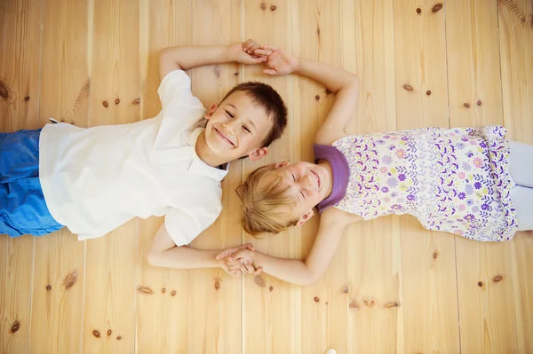 Two kids lying down on the floor — Stock Photo, Image