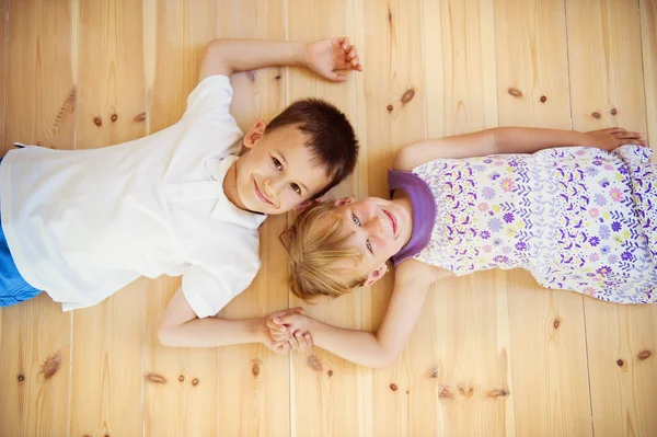 Twee kinderen liggen op de vloer — Stockfoto