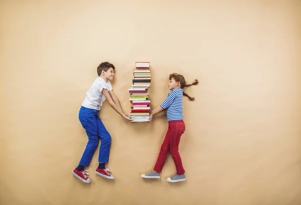 Crianças felizes brincando com livros — Fotografia de Stock