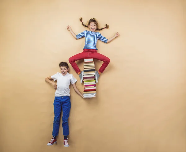 Niños jugando con un grupo de libros —  Fotos de Stock