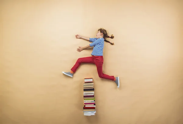 Girl is playing with group of books — Stock Photo, Image