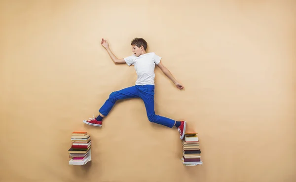 Boy is playing with group of books — Stock Photo, Image