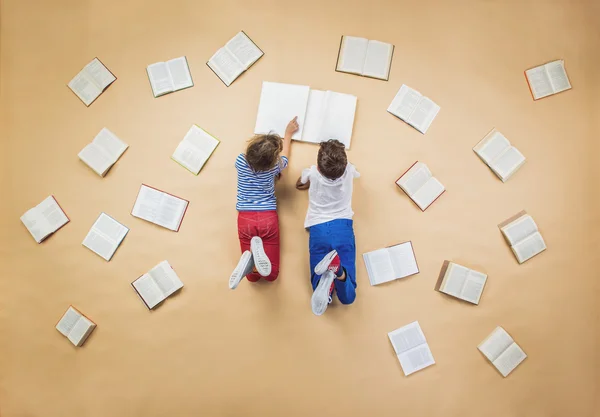 Los niños están leyendo un libro en el suelo —  Fotos de Stock