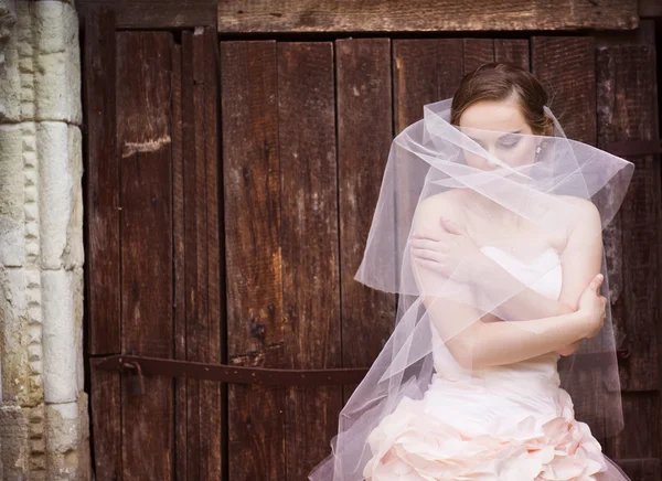 Sposa in piedi accanto alla vecchia cappella . — Foto Stock