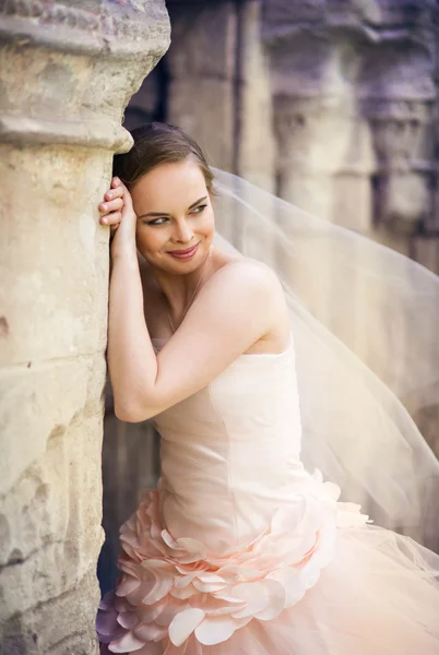 Bride standing by old chapel. — Stock Photo, Image