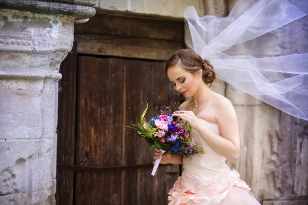 Bride by the old stone chapel. — Stock Photo, Image