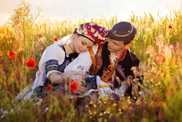 Kärlekspar i solnedgången fält. — Stockfoto