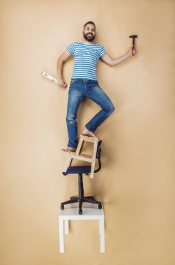 Handyman standing on a pile of chairs clipart