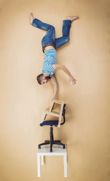 Hombre de pie sobre un montón de sillas — Foto de Stock