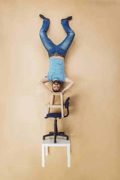Homem em pé sobre uma pilha de cadeiras — Fotografia de Stock