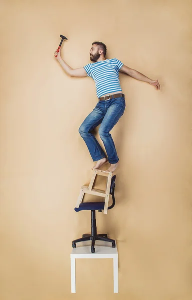Handyman in piedi su un mucchio di sedie — Foto Stock