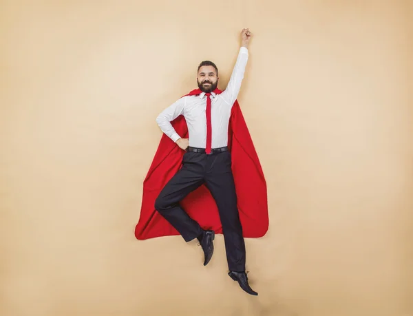 Superman pose bär en röd mantel. — Stockfoto