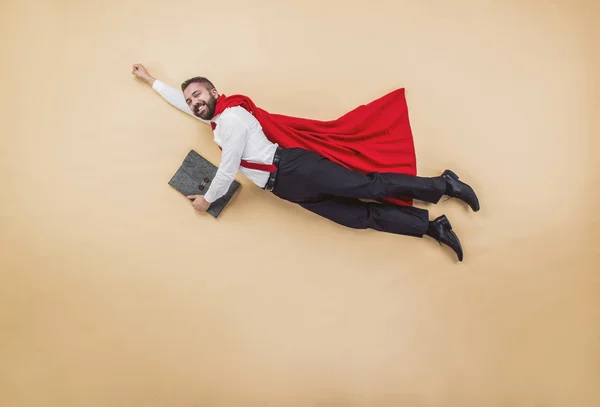 Менеджер в супермене позирует в красном плаще — стоковое фото