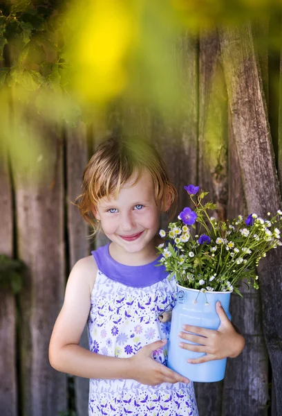 Mädchen hält Wiesenblumen in der Hand und lacht — Stockfoto