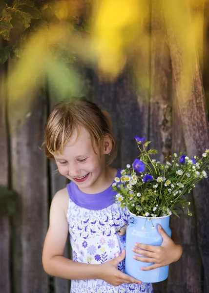 Chica sosteniendo flores del prado y riendo — Foto de Stock