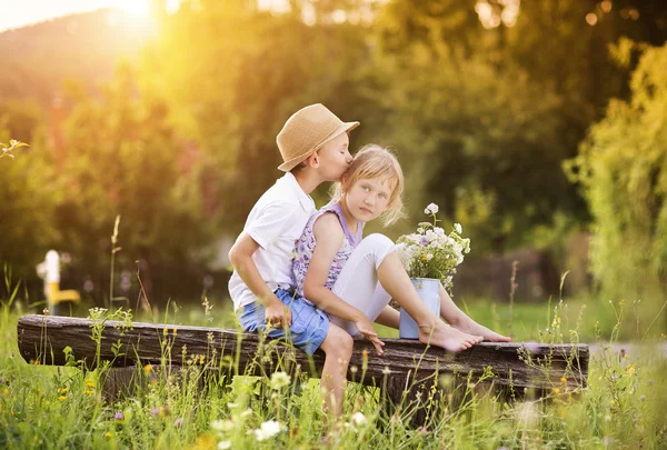 Boy and girl sitting on bench — Stock Photo, Image