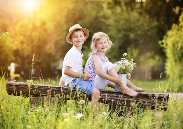 Pojke och flicka sitter på bänken — Stockfoto