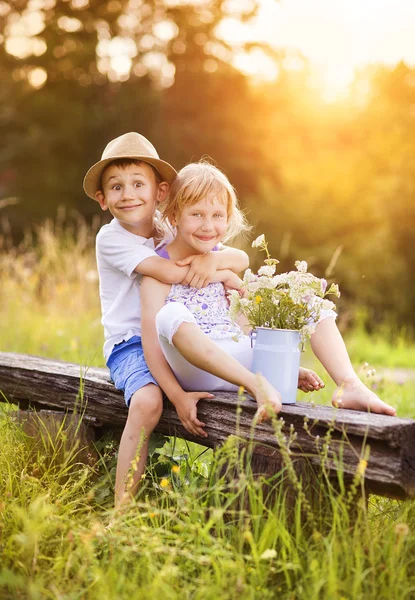 Menino e menina sentados no banco — Fotografia de Stock