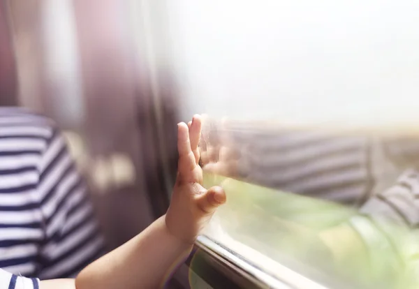 Рука мальчика касалась стекла в поезде — стоковое фото