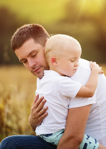 Отец и сын обнимаются на природе — стоковое фото