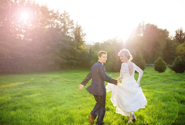 Pareja de boda corriendo en el parque — Foto de Stock