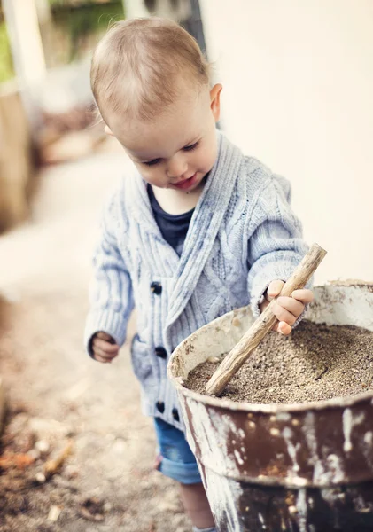 Pequeño niño jugando con viejo cubo — Foto de Stock