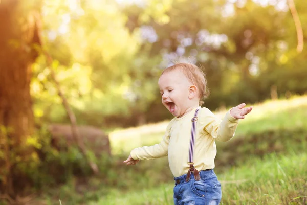 Lille pojken roar sig i en park — Stockfoto