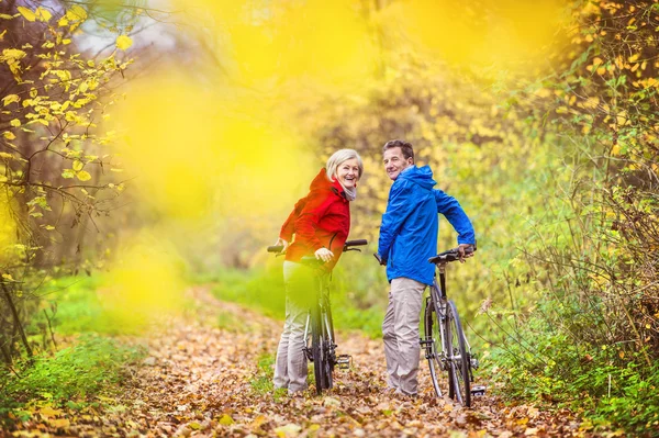 Aktywnych seniorów o spacer z rowerami — Zdjęcie stockowe