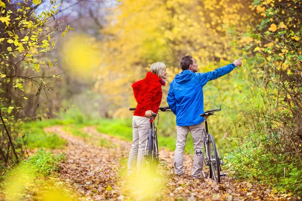 Anziani attivi che camminano con le bici — Foto Stock