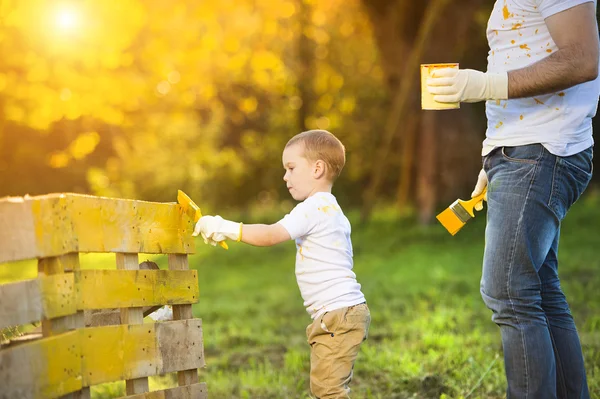 Niño y su padre pintando cerca de madera —  Fotos de Stock