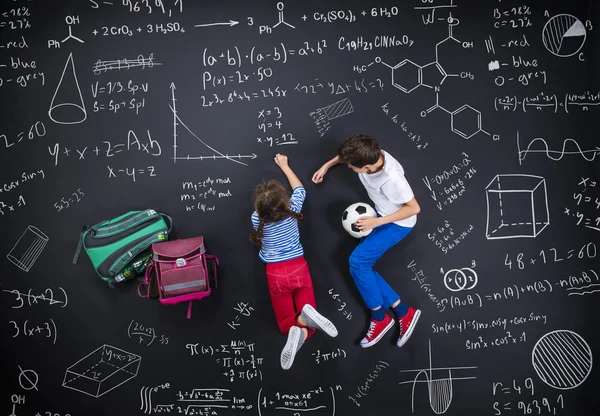 男の子と女の子が黒板の前で学習 — ストック写真
