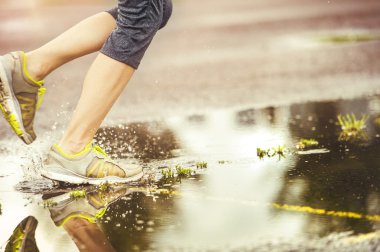 Woman running in rainy weather. clipart