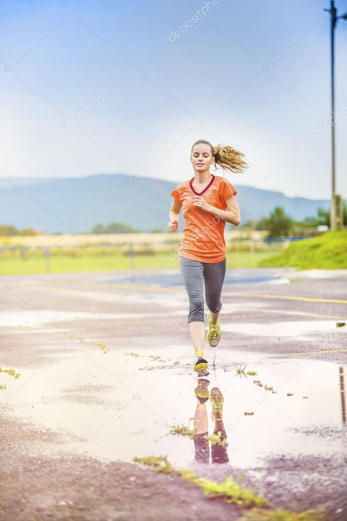 Woman running in rainy weather.