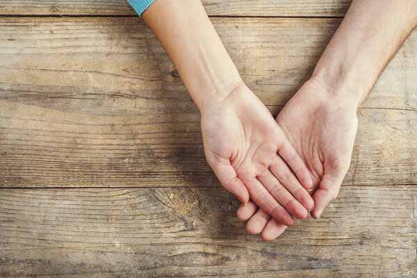 Hands of man and woman holding together.