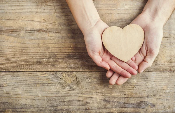 Hands of man and woman holding a heart together — Stock Photo, Image