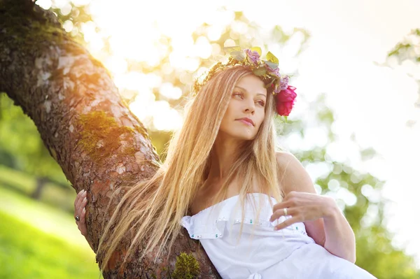 Mulher com grinalda floral ao pôr do sol — Fotografia de Stock