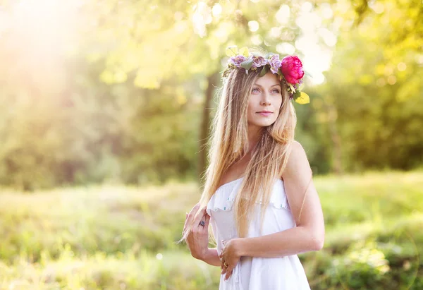 日没の花の花輪を持つ女性 — ストック写真