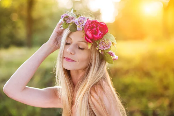 Žena s květinovým věncem v západu slunce — Stock fotografie