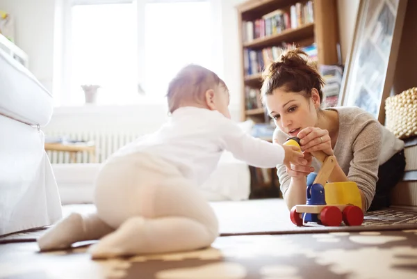 Dziecko dziewczynka gra z matką na dywan — Zdjęcie stockowe