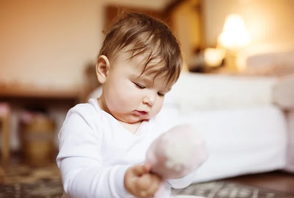 Schattig klein babymeisje in een woonkamer. — Stockfoto