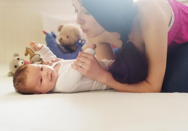 Moeder met haar babymeisje thuis — Stockfoto